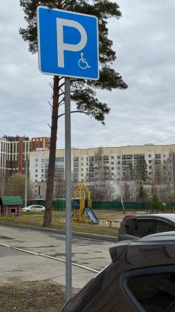 У входа в здание находится знак "Парковка для инвалидов"